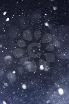Abstract falling snow texture on dark blue background.