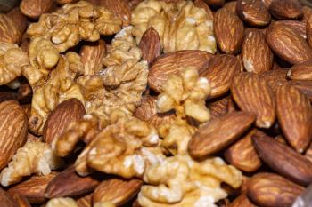 Peeled almond seeds and walnuts, close up background.