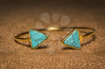 Vintage gold bracelet with blue turquoise, modern geometric shapes.