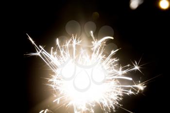 Glowing bright party sparkler in the dark background.