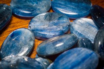 Natural blue kyanite stone, oval shape beads background.