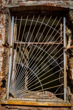 Rusted bars on the windows in ruined abandoned building background.