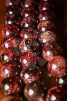 Dark red garnet, natural stone beads, january birthstone macro background.