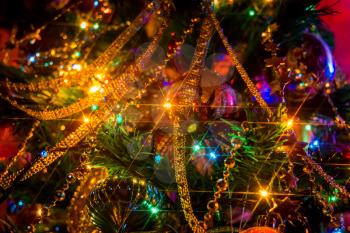 Artificial christmas tree decorated with colorful lights glowing in the night.