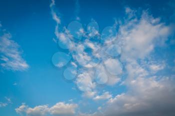 Blue sky with soft dark clouds, natural background.