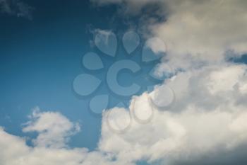 Blue sky with soft dark clouds, natural background.