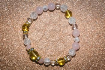 Macro of beaded bracelet made of natural yellow citrine, pink and white quartz stones.