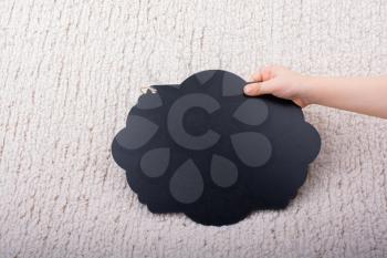 Black speech bubble shaped notice board in hand on white background