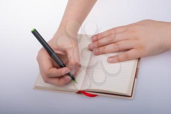 Human hand using pen to write down short note on notebook