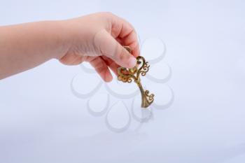 Child hand holding a retro styled decorative key