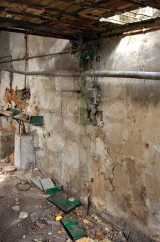 Abandoned factory interior with drug use paraphernalia on the ground.