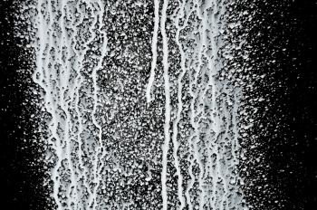 White paint splashed over black background. Abstract texture.