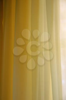 Transparent curtain background texture. Shades of yellow.