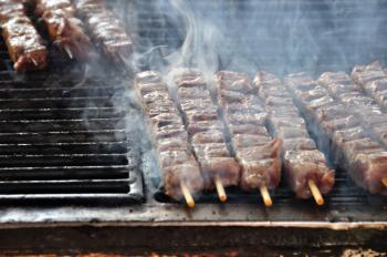 Souvlaki meat skewers on hot grill. Greek food background.