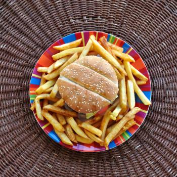 Cheeseburger and french fries dish. Fast food background.