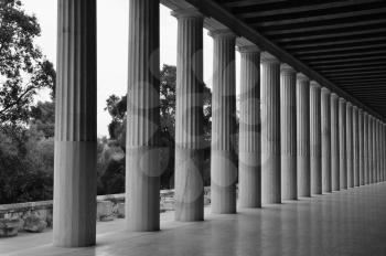Doric columns in stoa of attalos covered walkway in the ancient agora of Athens, Greece. Black and white.