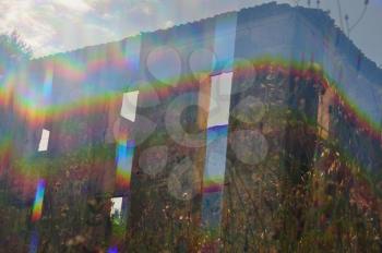 Bright light leaking through the windows of an abandoned house and overgrown plants. Abstract prism distortion on sunny day.