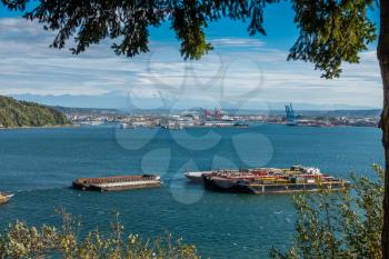 Barges are anchored at the Port of Tacoma with Mount Rainier in the distance.