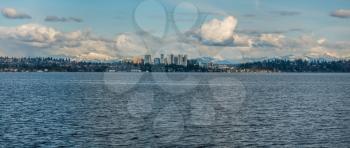 Panorama shot of the skyline of Bellevue, Washington with the Cascade Mountains behind.