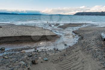 A stream flows across the shoreline at Seahurst Park on its way to the Puget Sound. Photo take in Burien, Washington.