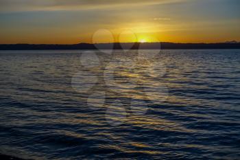 Sun sets creating a serene dellicate panorama over the Putget Sound in Washington State