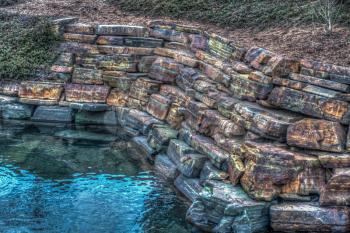 HDR image of a wall by a pond that looks radioactive. HDR image.