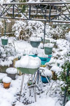 Snow covers planters in a back yard in Burien, Washington.
