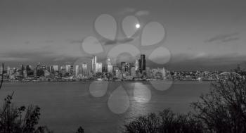 A bright full moon shines over the Seattle skyline.