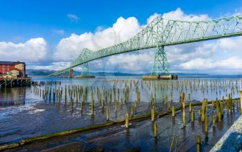 A veiw of the Astoia-Megler bridge that spans the Columbia River. Old pilings in the forground.