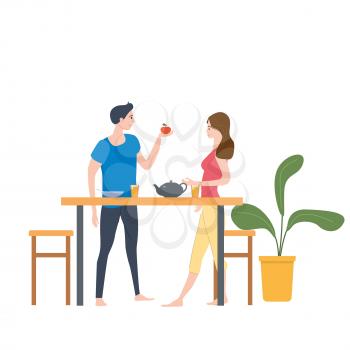 Cute loving couple at table, drinking tea or coffee and eating together at home.