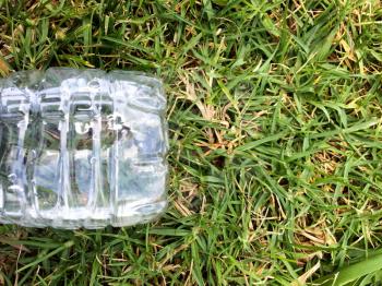 Plastic water bottle close up on green grass nature environment concept for recycling