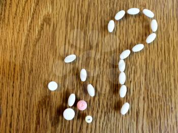 Medicine pills making question mark sign with open copy text space
