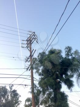 Electric power lines with jet stream and blue sky