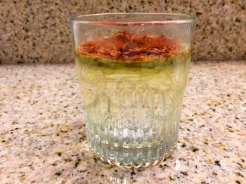 Saffron in water glass dissolves red and yellow