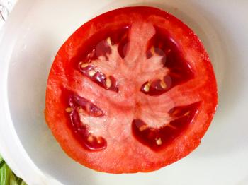 tomato half on plate juicy red with seeds close up