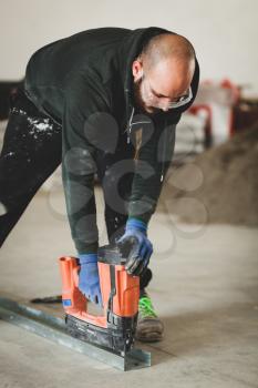 Worker at work in the construction of a plasterboard wall.