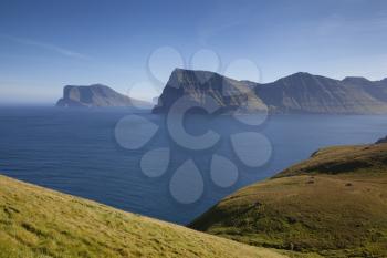 Kallur lighthouse hiking area showing Kunoy and Vidoy islands on a bright sunny day with blue sky