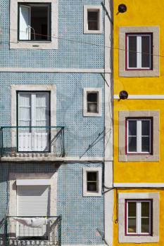 Bright blue and yellow facade  with square symmetrical windows in Lisbon, Portugal