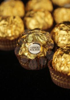 Chocolate Ferrero rocher on a line on a black background