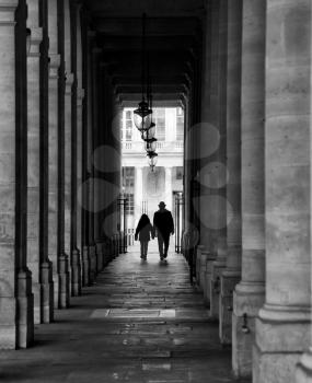Dad and kid walking in a corridor in Paris.  Black and white picture.
