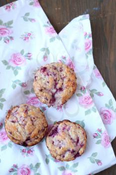 Homemade fruits muffins on a wooden pink flowered tablecloth