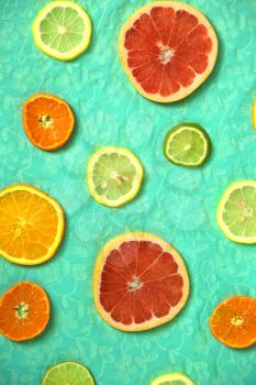 Fresh slices of citrus on a turquoise background