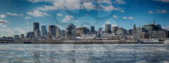 Montreal by a very cold day.  St-Lawrence river with ice with downtown Montreal in background 