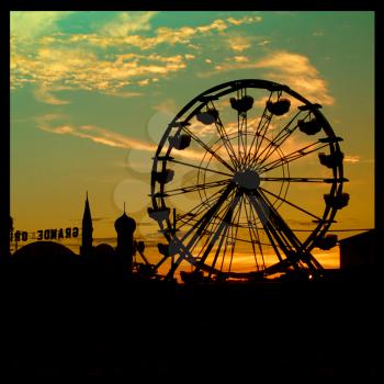 Silhouette of a big ferris wheel and fair during sunset time