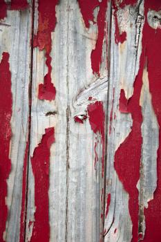 Red peeling painting on wooden barn door