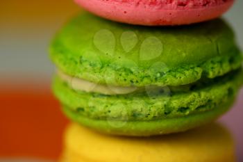 Close up of tasty macaroons on colourful background