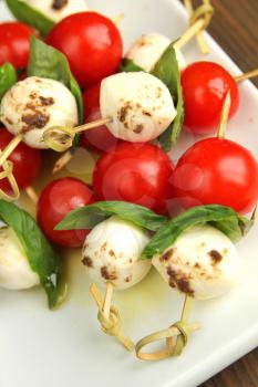 Tomato,  bocconcini and fresh basil on skewer with balsamic and olive oil