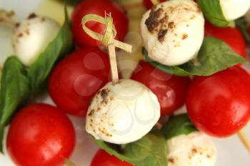 Delicious tomato,  bocconcini and fresh basil on skewer with balsamic and olive oil
