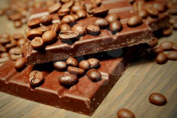Dark chocolate with coffee beans on top on a wooden background