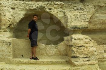 Royalty Free Photo of a Man Standing at a Rock Formation